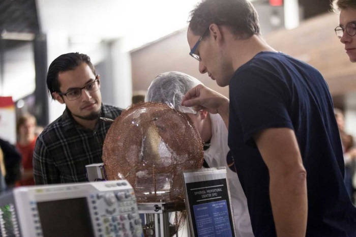 Showing the glass sphere detector to guests at an outreach event