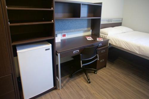 Example accommodations in Brant House and David C. Smith House. Room features a bed, desk, mini fridge, wardrobe and television. 