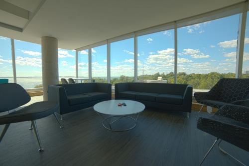 Common room in the summer accommodations. The rooms features couches and chairs in the room with the Kingston landscape visible through the windows. 