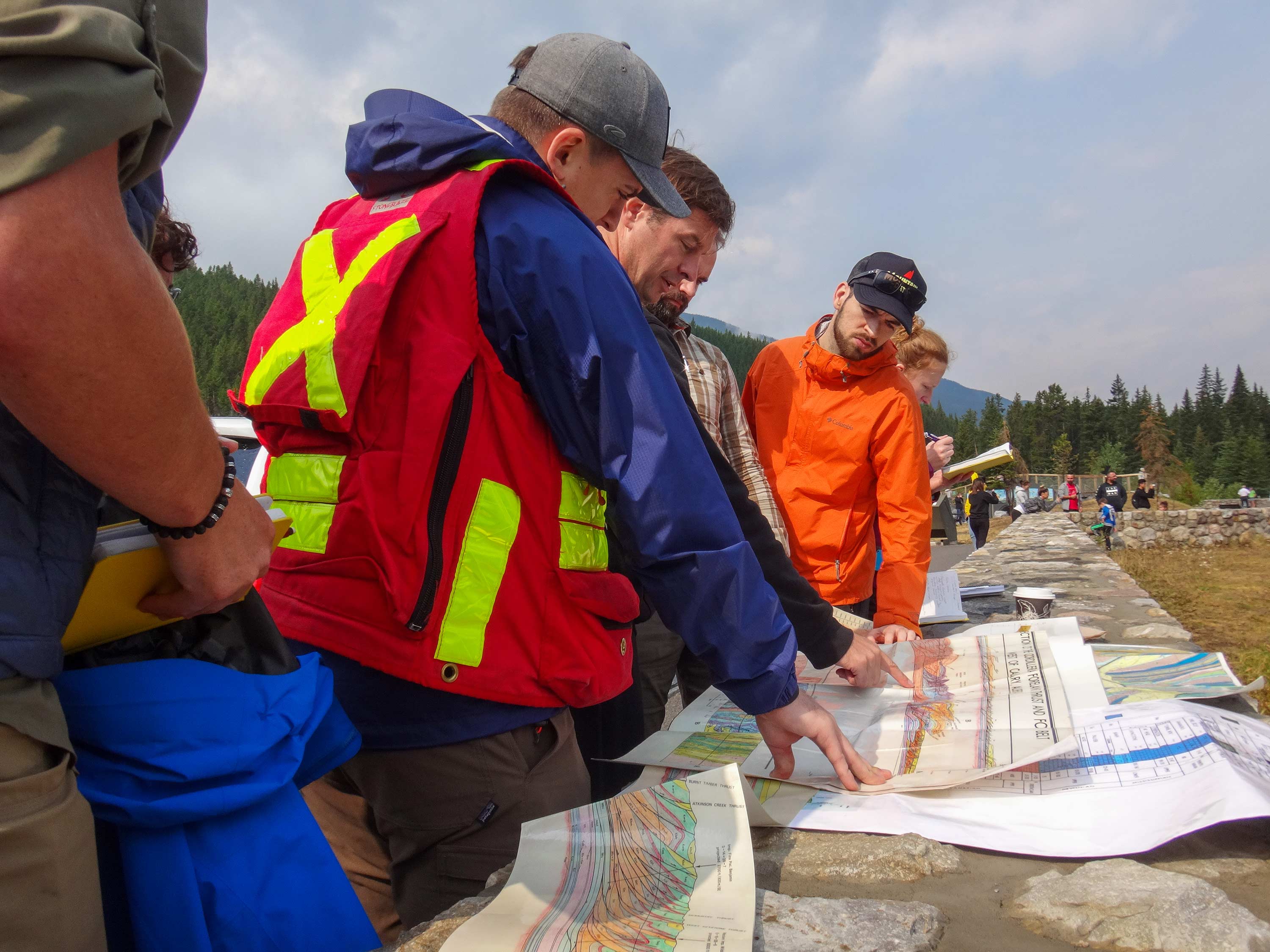 group of students in safety gear looking at a site plan