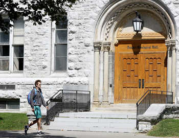 Person walks by Theological Hall